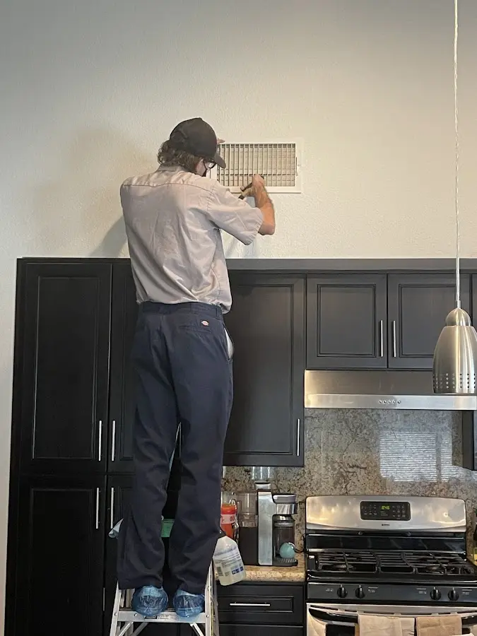 Technician inspecting an air vent during HVAC service in Cameron Park